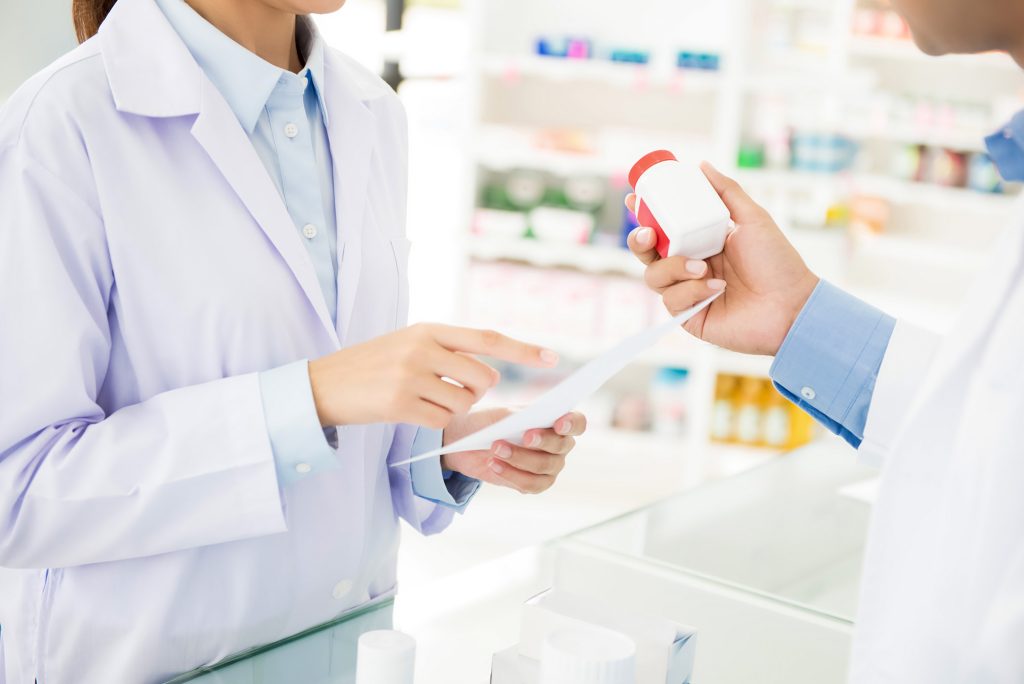 Pharmacist handing medication to a client.